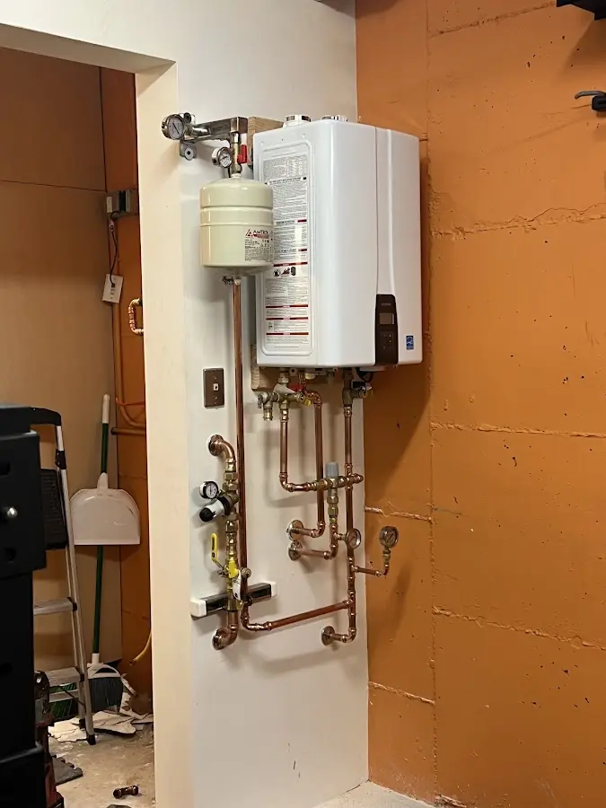 Plumbing technician inspecting water heater connections in Carefree